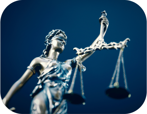 lib Statue of Lady Justice holding scales, symbolizing law and fairness, against a dark blue background.